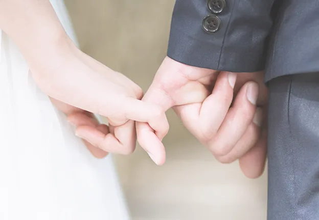 指を絡め合う新郎新婦の手元